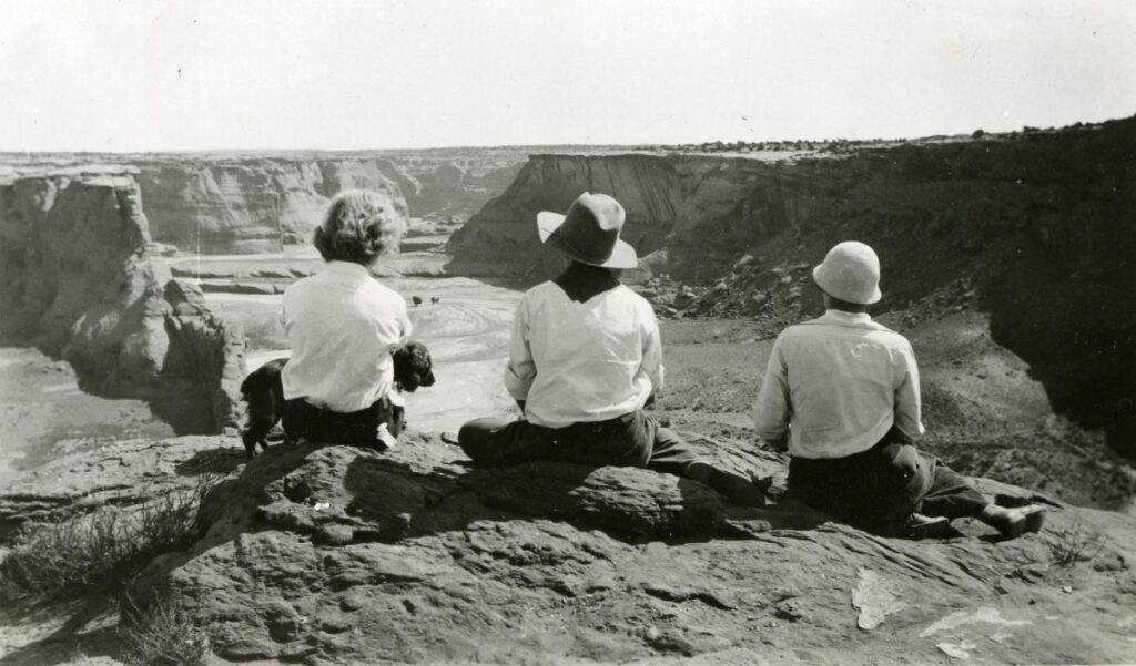 Ann Kent (with a dog), Leonora Frances Curtin, Leonora Scott Muse Curtin, sitting on a rim overlooking Canyon de Chelly. 